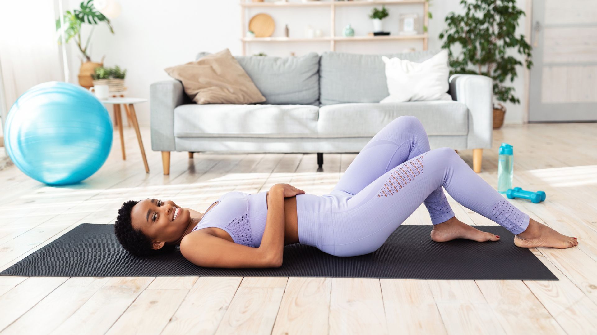 woman lying on her back on yoga mat