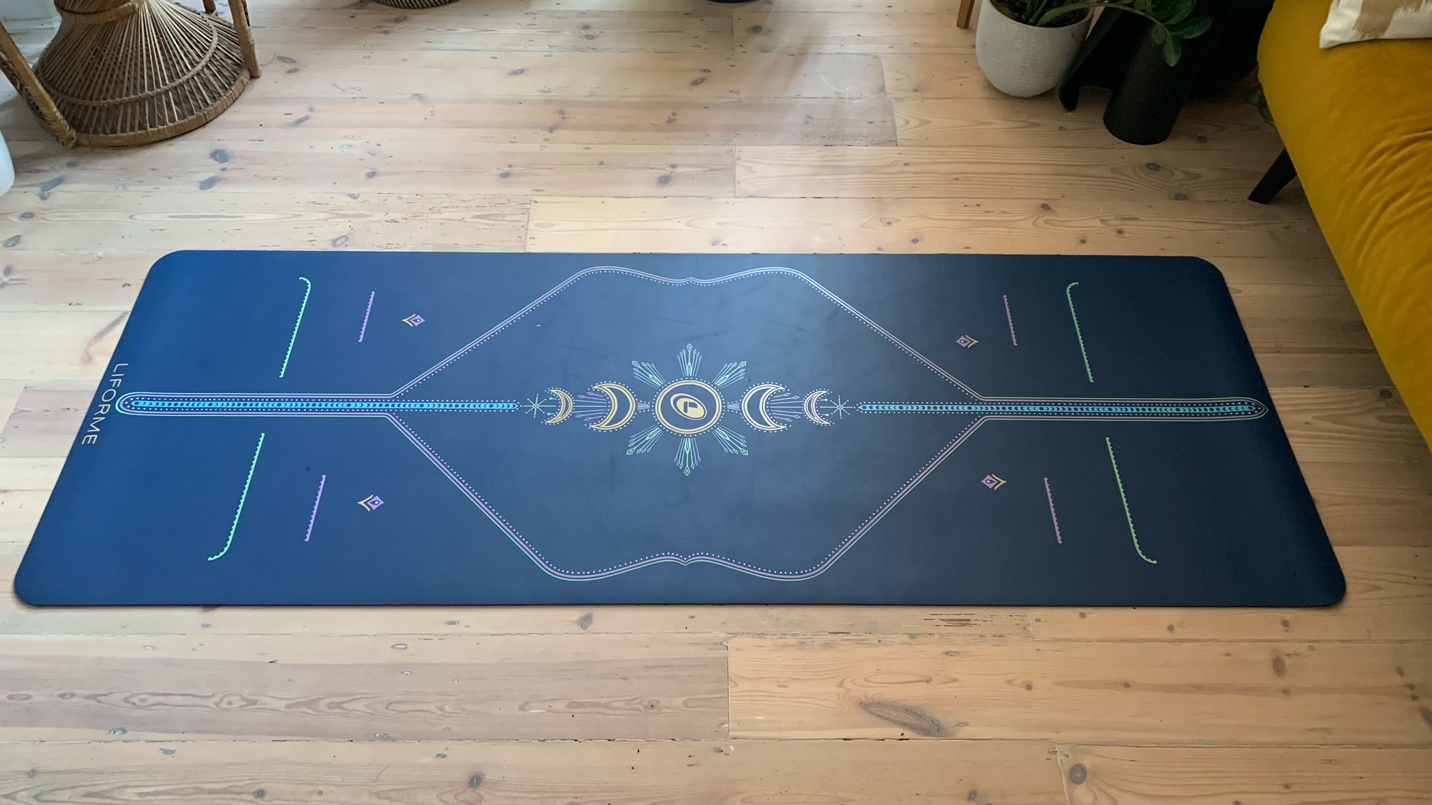 The Liforme Yoga Mat rolled out on a wooden floor