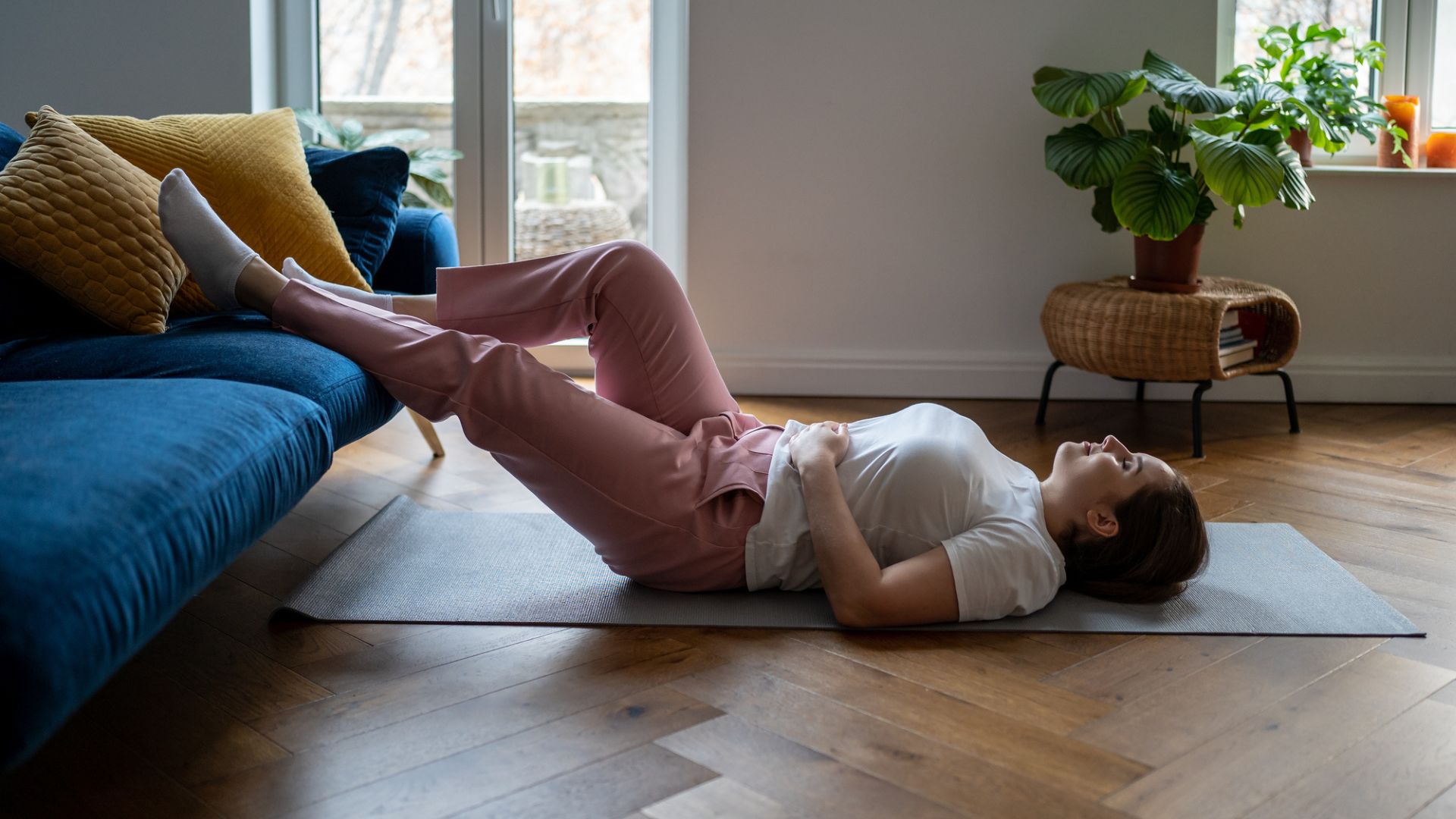 woman relaxing on floor with legs on sofa