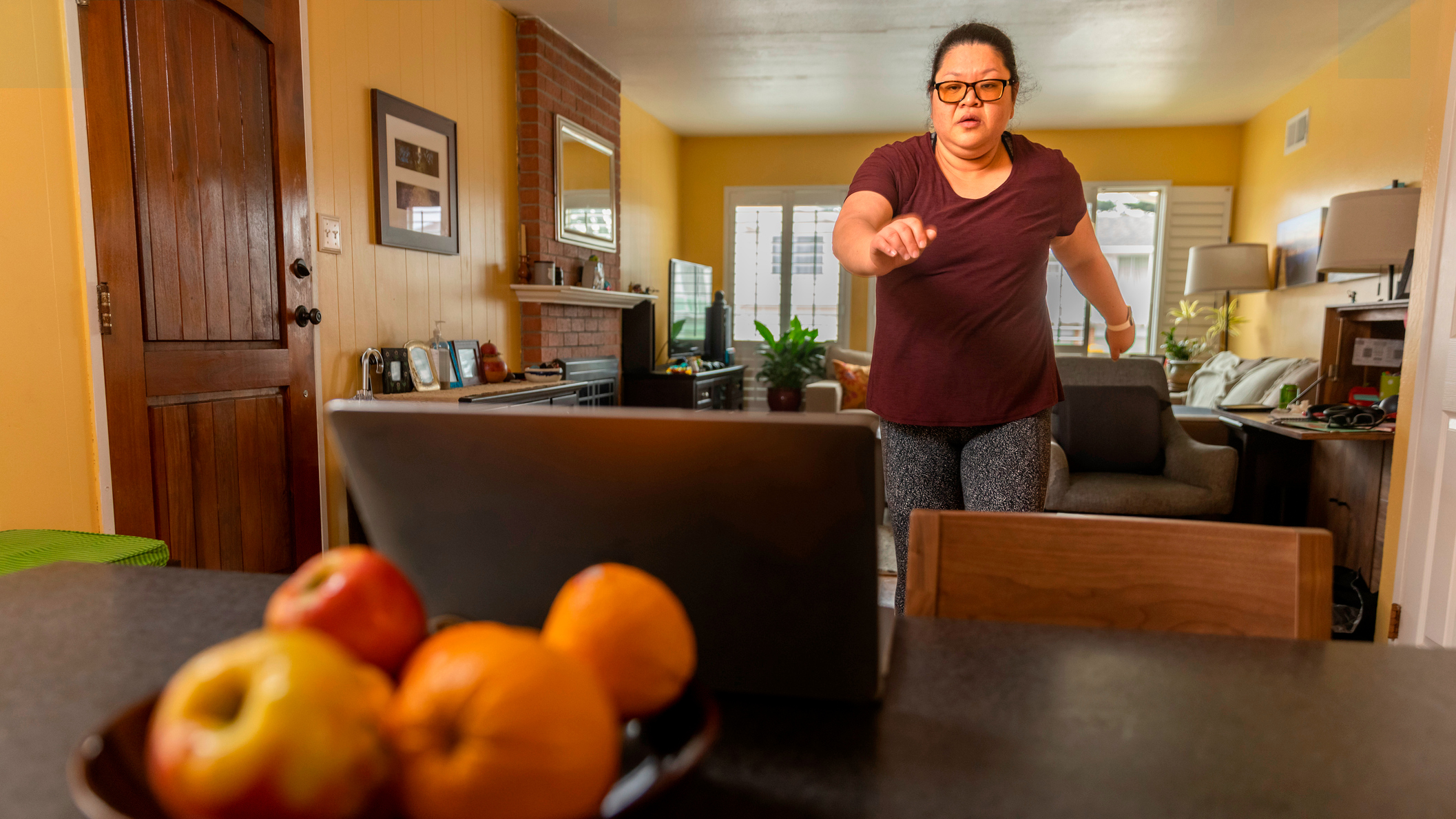 Woman exercising in front of a laptop at home
